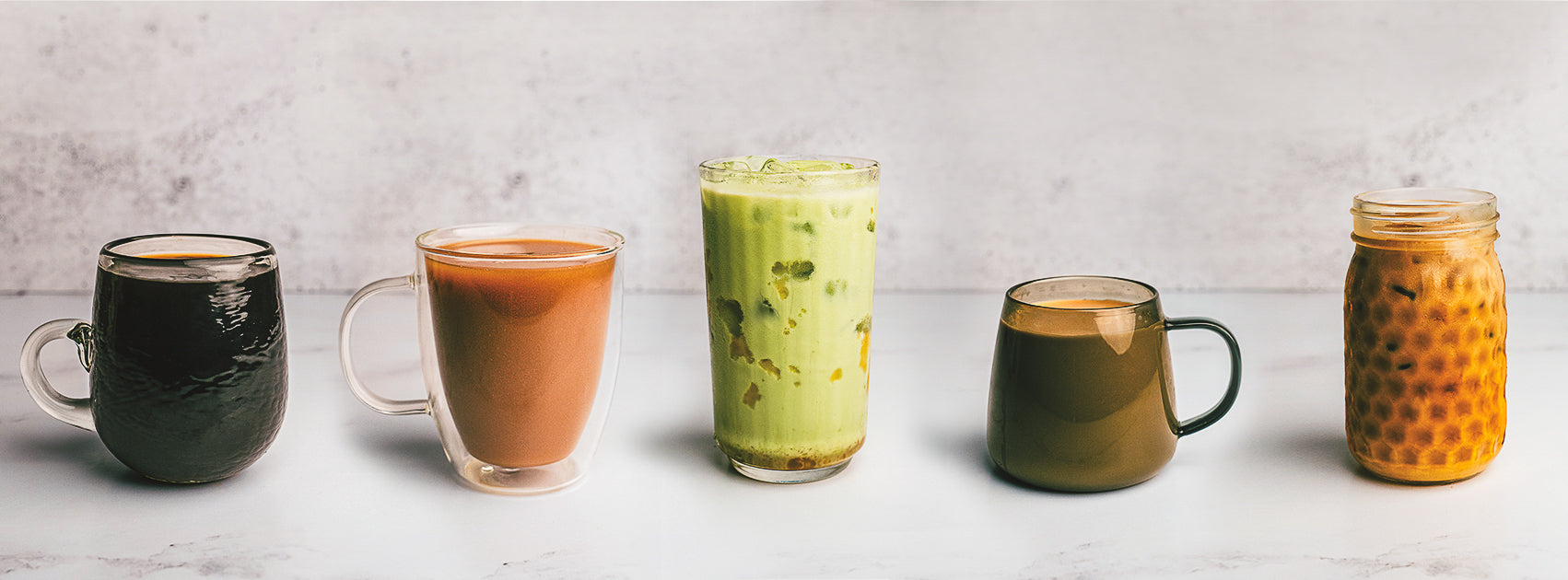 Five different types of beverages in various containers on a light background